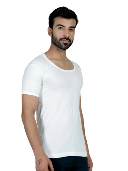 Man wearing a plain white t-shirt against a light green background
